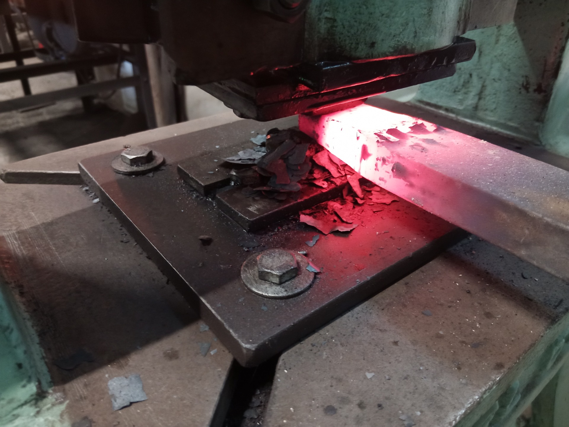 Red-hot iron under a 15-metric-ton screw press at a temperature of approximately 950 °C during hand forging
