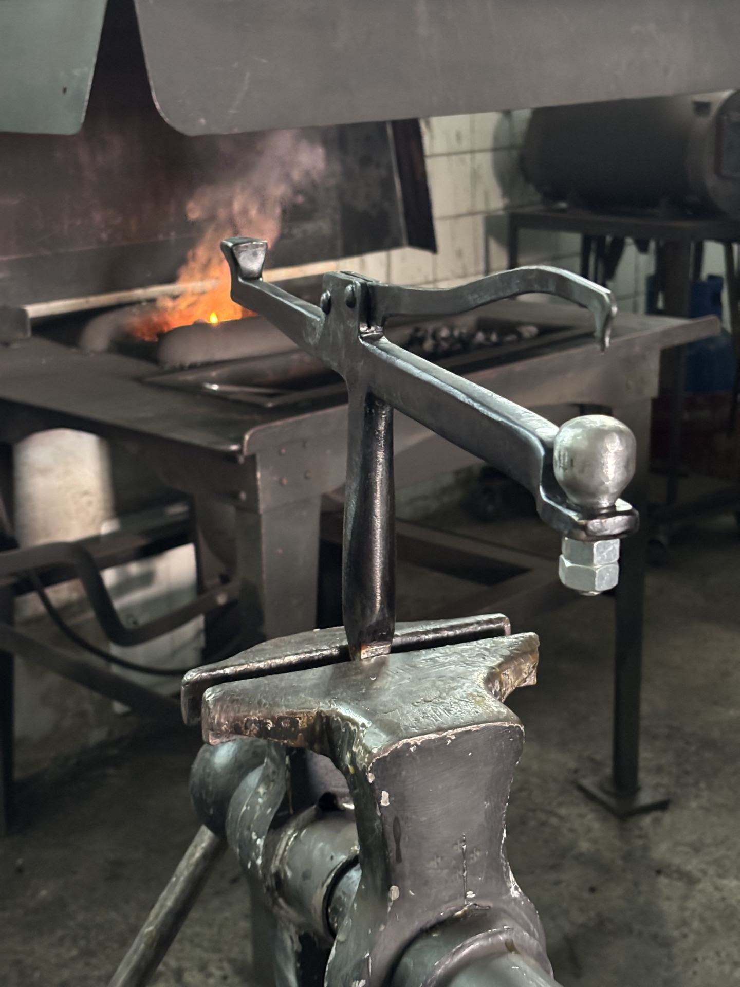 A snarling iron, used for chasing and repoussé on metal vessels. In the image, it is clamped in a blacksmith's vise.