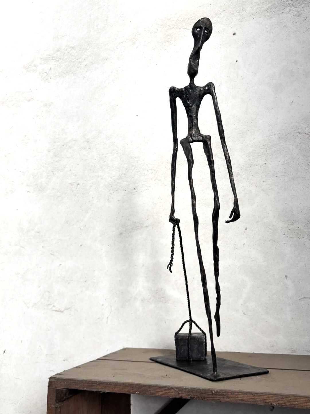 View of the forged sculpture Mea Culpa III, depicting a figure pulling a heavy burden