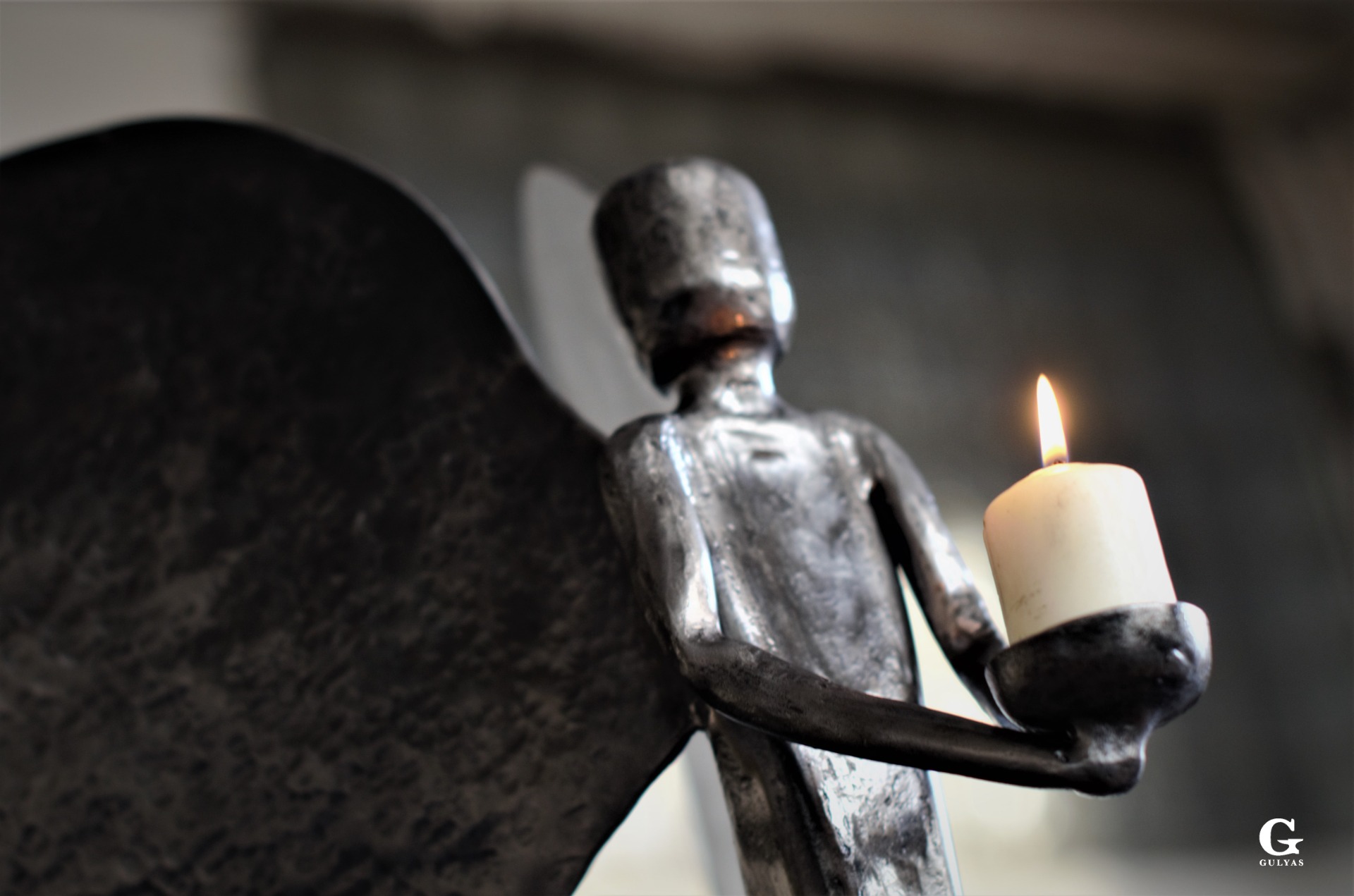 Detailed shot of a hand-forged angel sculpture holding a candle by artist blacksmith Ladislav Gulyás